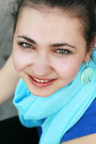 在一条蓝色的围巾中一个美丽年轻黑发的肖像 — 图库照片