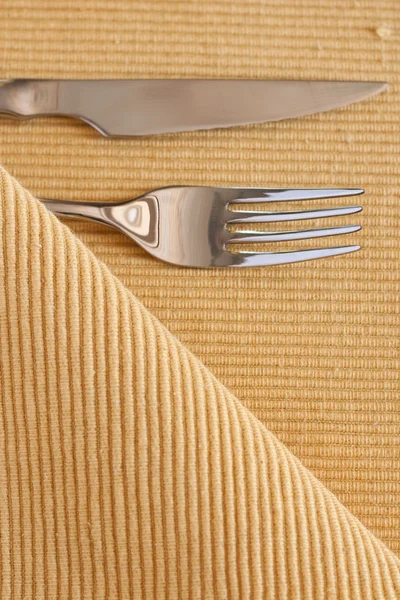 Gabel, Messer und gelb gestreiftes Tischtuch — Stockfoto