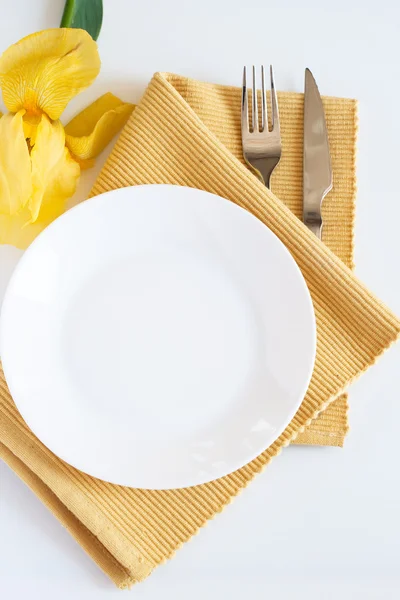 Gabel, Messer, Teller und gelbe Irisblume — Stockfoto