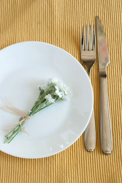 Garfo, faca, prato e pequenas flores brancas — Fotografia de Stock