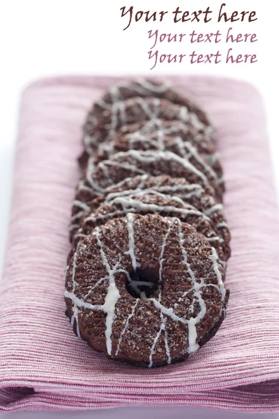 Leckere Schokoladenkekse mit Sahnehäubchen auf rosa Serviette — Stockfoto