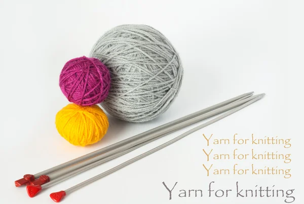 Esferas brilhantes de fios para tricotar e tricotar agulhas — Fotografia de Stock