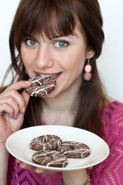 Portrait of a beautiful young brunette with tasty biscuits — Stock Photo, Image
