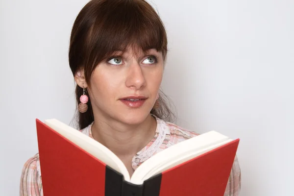 Sladká mladá bruneta čtení učebnice a sny — Stock fotografie