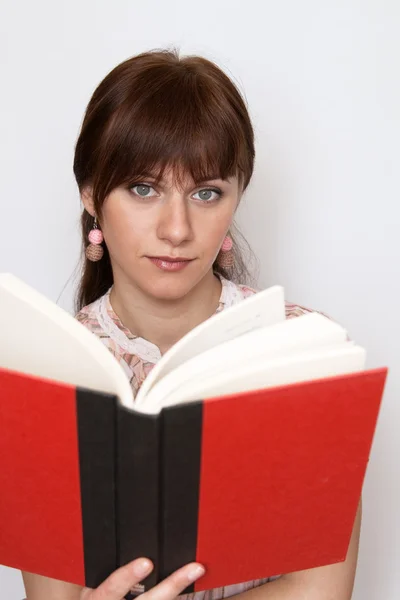 Sladká mladá bruneta v růžové košili, čtení knihy — Stock fotografie