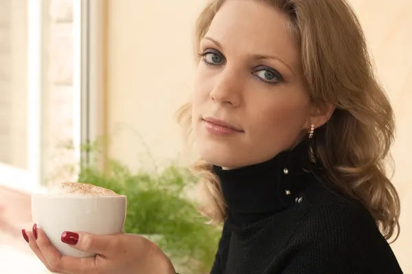 Porträt einer jungen hübschen Blondine mit einer Tasse in der Hand — Stockfoto
