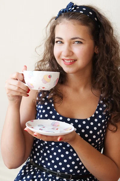 Beautiful young brunette holding a large cup — Stock Photo, Image