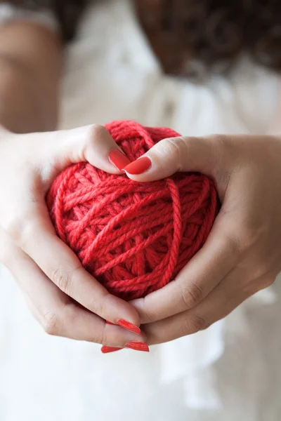 Big ball of red wool in the hands of a girl — Stock Photo, Image