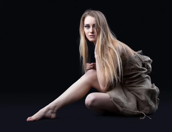 Chica desnuda en hessian sentarse en la oscuridad — Foto de Stock