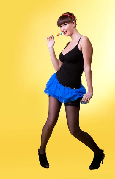 Красавица с lollipop улыбнуться вам на желтый — стоковое фото