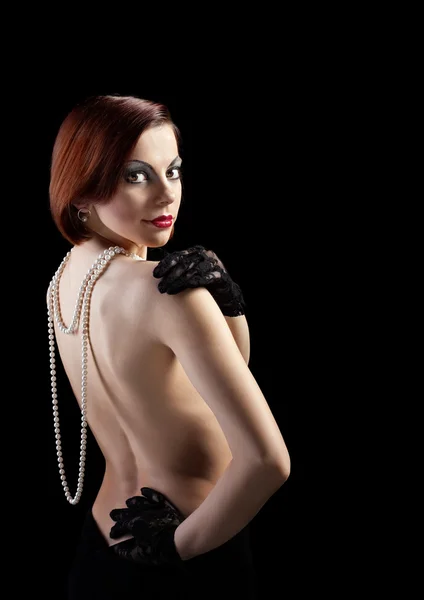 Naken kvinna stående med pärlor och handskar i retro makeup — Stockfoto