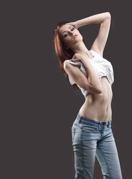 Sexy jovem mulher em jeans e tanque top despir — Fotografia de Stock