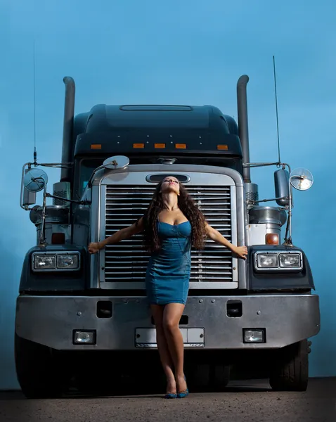 Young pretty girl posing before huge cargo truck — Stock Photo, Image