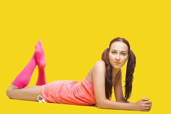 Kobieta uroda jak nastolatek leżał na żółty — Zdjęcie stockowe