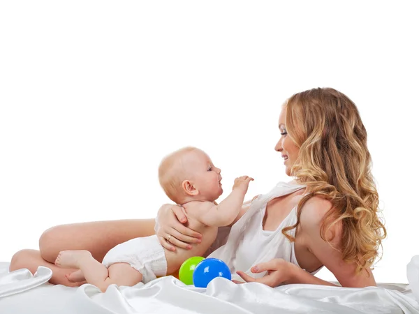 Pretty woman play with son in bed isolated — Stock Photo, Image