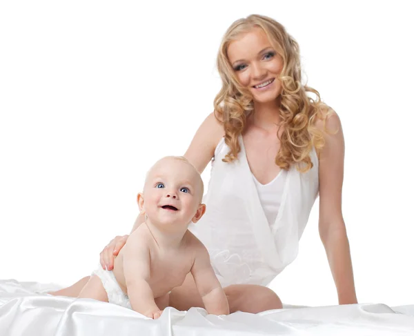 Bellezza donna sorriso con figlio sul letto isolato — Foto Stock