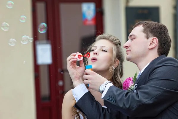 Just married couple blow bubbles — Stock Photo, Image