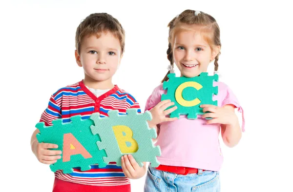 Pojke och flicka håller bokstäver — Stockfoto