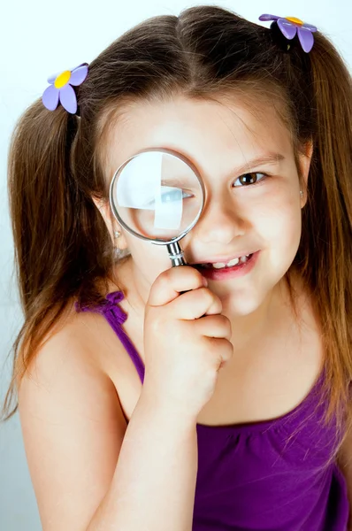 Bambina con una lente d'ingrandimento — Foto Stock
