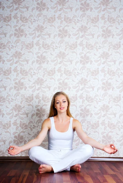 Молодая женщина сидит в позе йоги — стоковое фото