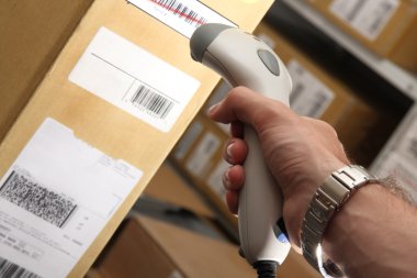 Man with barcode reader works on warehouse clipart