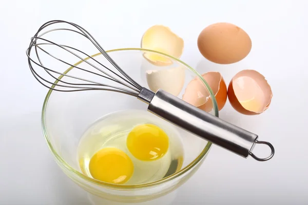 Eggs and whisk — Stock Photo, Image