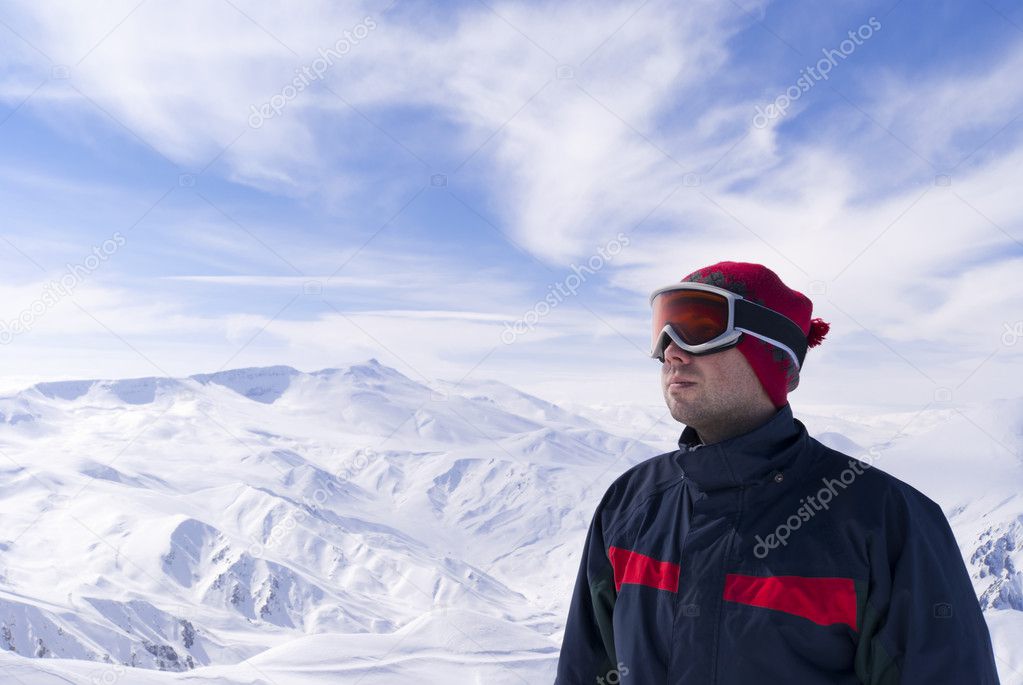 Young skier is looking on the mountain landscape