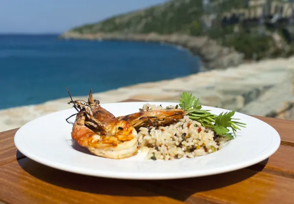 stock image The dish with srimps and rice near mediterranean shore.