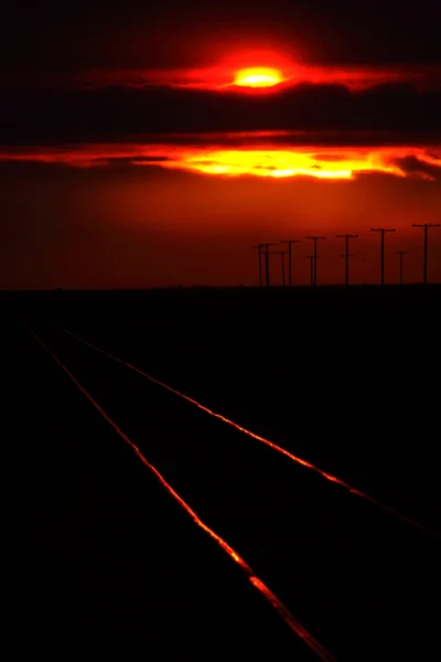 Setting sun lighting railway tracks in scenic Saskatchewan