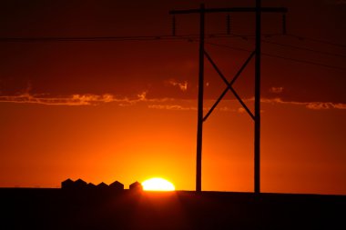 hermosa puesta de sol detrás de las torres de energía de saskatchewan