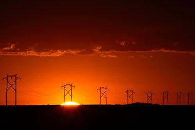 hermosa puesta de sol detrás de las torres de energía de saskatchewan