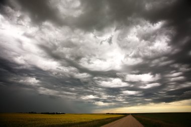 Storm clouds over Saskatchewan farm buildings clipart