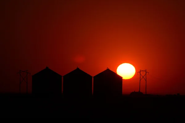 太阳在萨斯喀彻温金属粮仓后面的设置 — 图库照片