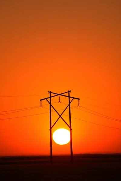 Sun setting behind Saskatchewan hydro tower — Stock Photo, Image