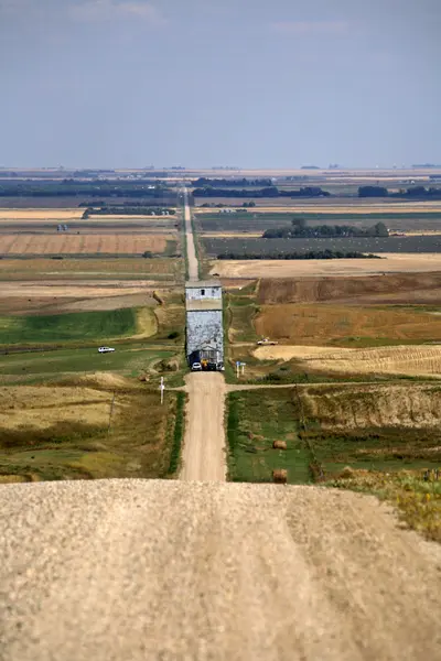 Elevador de grãos sendo movido ao longo da estrada rural de Saskatchewan — Fotografia de Stock