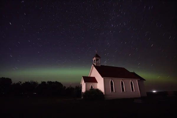 Luces boreales y huellas de estrellas sobre la iglesia de San Columba — Foto de Stock