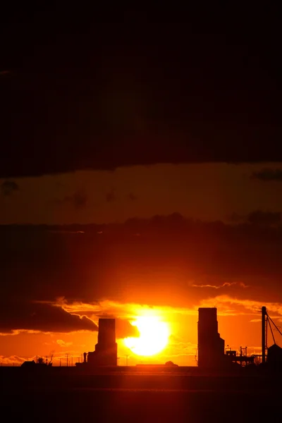 Solnedgången bakom två saskatchewan grain hissar — Stockfoto