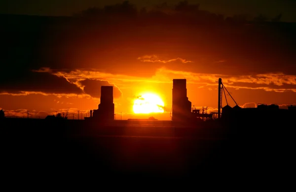 Solnedgången bakom två saskatchewan grain hissar — Stockfoto