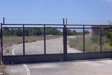 Locked gate leading to an abadonned terrain clipart