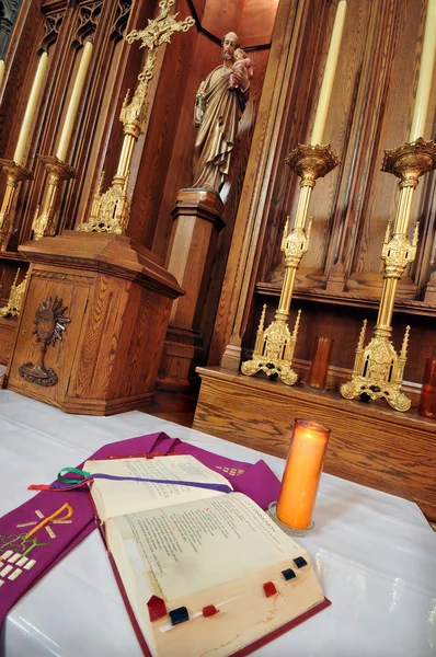 Altar católico na igreja. Bíblia aberta em primeiro plano . — Fotografia de Stock