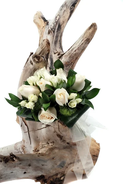 A bunch of flowers on white on tree stump — Stock Photo, Image
