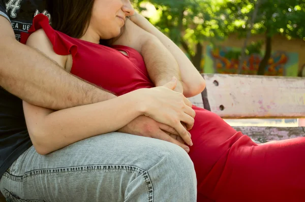 Любящая пара обнимается на скамейке — стоковое фото