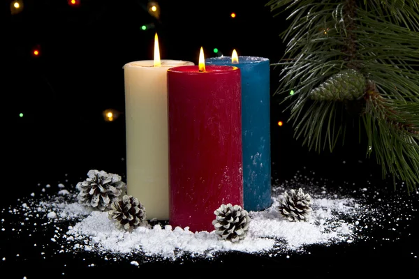 大雪覆盖的蜡烛在晚上与锥体 — 图库照片