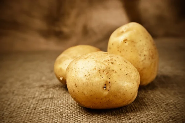 Свежий картофель на фоне мешка Лицензионные Стоковые Фото