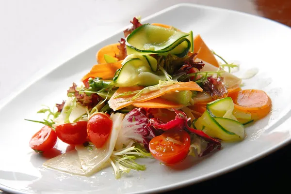 Ensalada con verduras frescas, tomates y aguacate en platos —  Fotos de Stock