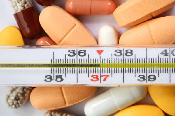 Thermometer and drugs Royalty Free Stock Images