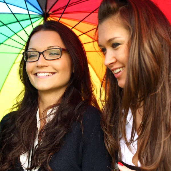 Smiling girlfriends under umbrella — Stock Photo, Image