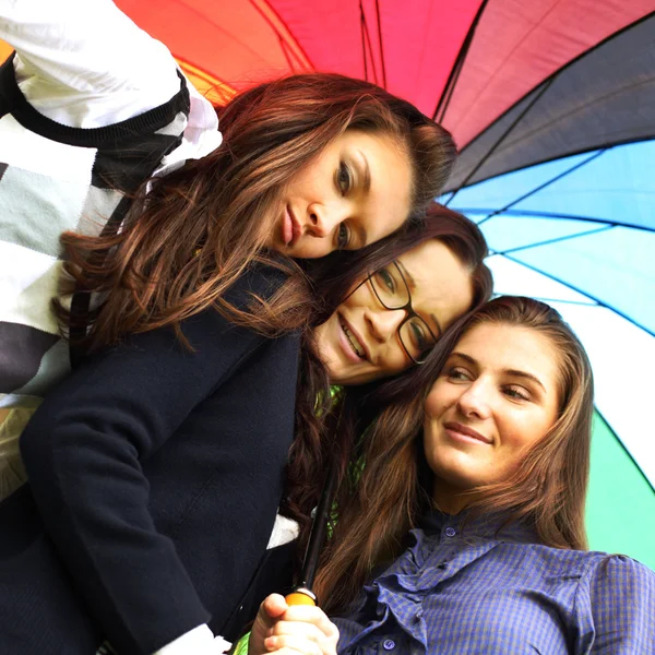 Lächelnde Freundinnen unter Regenschirm — Stockfoto