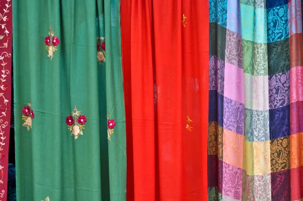 Coloridas telas estampadas que cuelgan en una fila — Foto de Stock