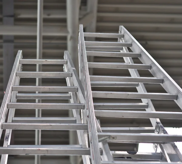 Close-up de duas escadas de metal em um fundo escuro — Fotografia de Stock